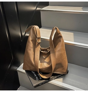 Detailed macro view of brown vintage PU leather tote bag with metallic triangle logo