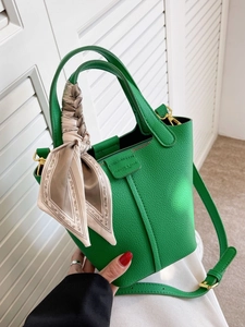 Vibrant green leather bucket bag with printed silk scarf handle and long shoulder strap