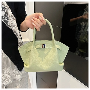 Detail of mint green bucket bag featuring lychee grain leather and silver buckle