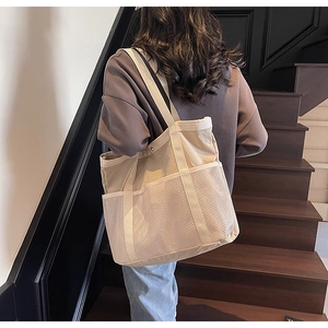 Detalle del bolso tote de lona con bolsillo de malla frontal y gran capacidad para viajes