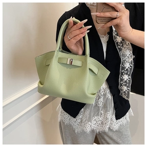 Detail of avocado green bucket bag showing high-quality lychee grain texture and silver buckle