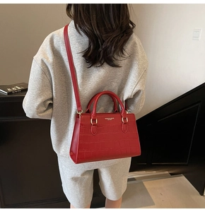 Detail view of red crocodile textured bridal handbag with elegant golden hardware