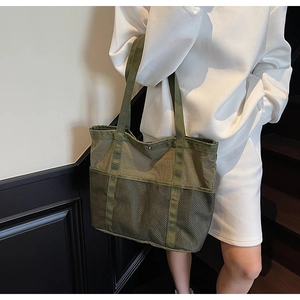 Primer plano del bolso tote de nailon verde oliva con bolsillo de malla al hombro