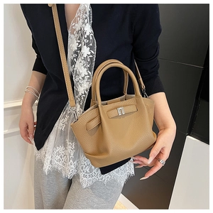 Close-up of litchi grain leather texture on camel bucket bag with silver hardware