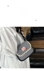 Detail of gingham canvas bag with lace trim, rabbit patch and strawberry pin decoration