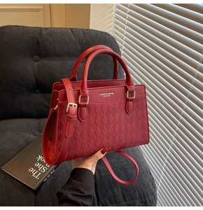 Detail of red bridal tote bag with diamond quilted texture and gold hardware details