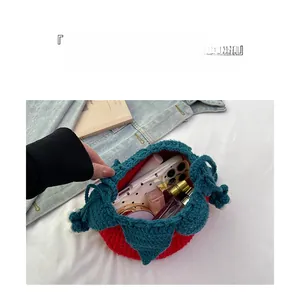 Detailed view of handmade knitted strawberry pouch storage capacity for cosmetics