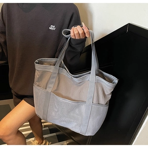 Vista de detalle del bolso gris de malla con bolsillos espaciosos y correas de hombro