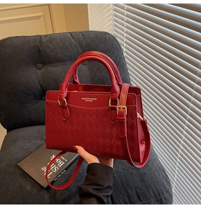 Detail of red quilted leather wedding handbag with gold hardware on a blue chair