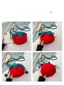 Detail view of handmade strawberry crochet bag showing texture, opening and base