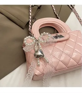 Pink quilted patent leather mini bag featuring pearl lace bow and silver chain strap