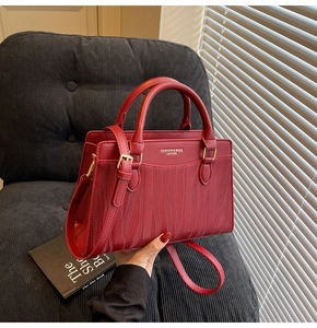 Detailed close-up of dark red leather bridesmaid tote bag with golden hardware detail