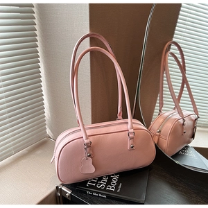 Detail of light pink faux leather underarm bag with top zipper and double handles
