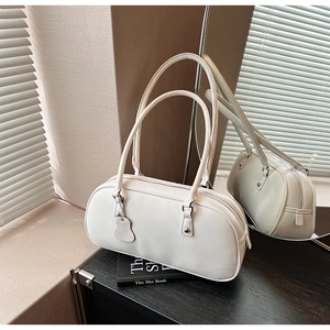 Detail view of cream white underarm bag with zipper closure and smooth leather texture