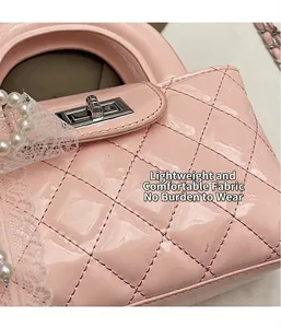Close-up of pink patent leather quilted handbag with lace trim and pearl chain details