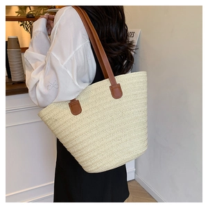 Detail of cream woven tote bag with brown leather handles in a cozy cafe setting