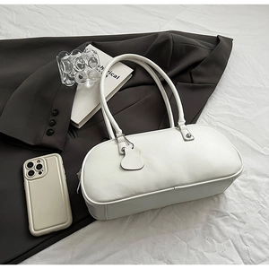 Detailed view of white PU leather bowling bag with extended handles on office attire