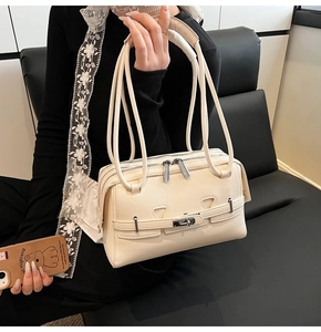 Detail of minimalist cream shoulder bag with double zippers and silver hardware