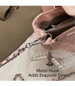 Detail of pink patent leather bag showing silver metal hooks and chain strap with pearls