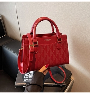 Close-up of red leather wedding tote bag with diamond lattice pattern and gold hardware