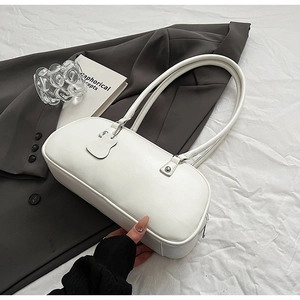 Minimalist white leather underarm bag with elegant heart charm and sleek strap detail