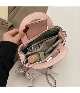 Pink patent leather mini bag interior showing space for phone, lipstick and perfume