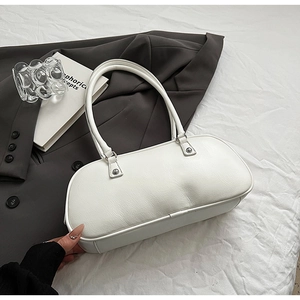 Close-up of white lychee texture leather underarm bag with silver metal studs detail