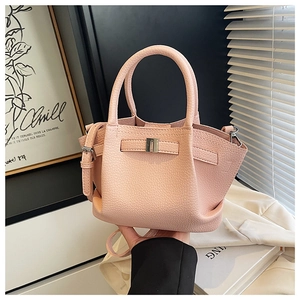 Detail of pink lychee leather bucket bag with metal buckle and adjustable strap