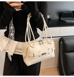 Detail of cream white faux leather bag featuring triple zippers and silver metal twist lock