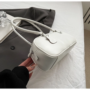 Macro detail of white faux leather underarm bag with silver zipper and slim shoulder strap