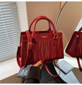 Close-up of red wedding tote bag with wave texture and adjustable leather strap