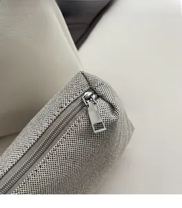 Detail of smooth silver metal zipper on grey and white woven canvas tote bag