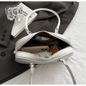 Top view of white underarm bag showing spacious brown interior for daily essentials