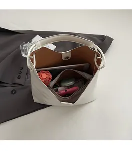 Interior view of white leather bucket bag showing large capacity with magnetic closure