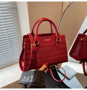 Close-up of red quilted leather tote bag with elegant gold hardware and top handle