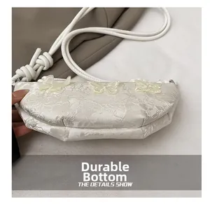 Detailaufnahme des abriebfesten Bodens und der Blumenstickerei einer weißen Tasche