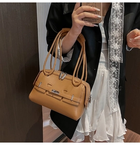Detail of caramel faux leather shoulder bag with silver zipper and strap texture