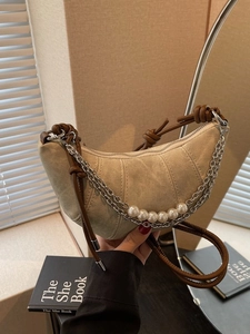 Minimalist beige crescent hobo bag with brown leather strap and decorative pearl chain