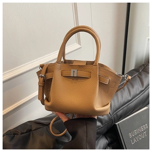 Detail of khaki bucket bag showing litchi grain leather texture and metal buckle accents