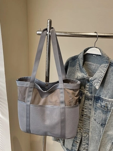 Bolso tote grande de nailon y malla gris colgado para viajes y uso diario funcional
