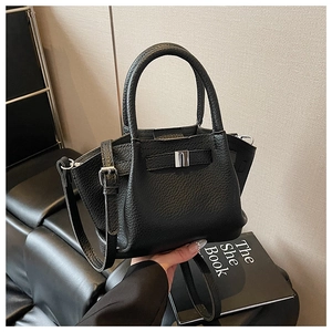 Detailed view of black lychee grain leather bucket bag with silver buckle and side gussets