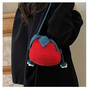 Macro shot of handmade strawberry knit crossbody bag showing detailed crochet stitches