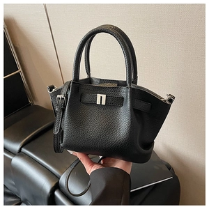 Detail of black textured leather bucket bag with silver metal lock and thin strap