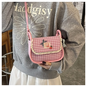 Detail of pink plaid canvas crossbody bag featuring lace trim and cute cartoon patches