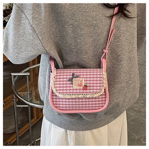 Detail of pink plaid crossbody bag featuring lace trim and a cute rabbit patch