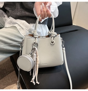 Detail of light grey lychee texture bucket bag with rope handle and round coin purse