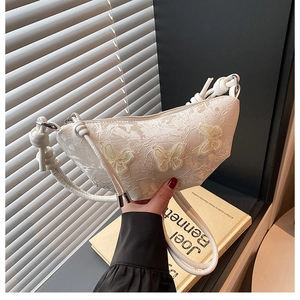 Detail der weißen Spitzen-Achseltasche mit 3D-Schmetterlingsstickerei und gewebtem Riemen