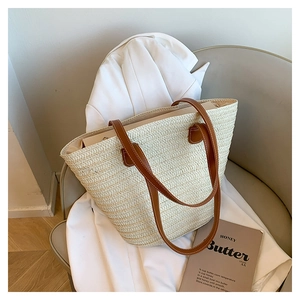 Detailed view of the woven tote bag on a chair showing the texture and leather straps