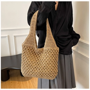 Detailed view of handmade hollow straw knit texture on a beige summer shoulder beach bag