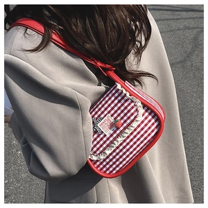 Detail of red and white checkered canvas bag with lace trim and strawberry patch
